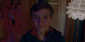 Movie still from “Better Nate Than Ever” (2022), directed by Tim Federle – A young man smiling for the camera with his mouth open; Close Up shot, High angle