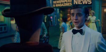 Movie still from “Better Nate Than Ever” (2022), directed by Tim Federle – A young man in a white suit and a bow tie; Close Up shot, Over the shoulder angle