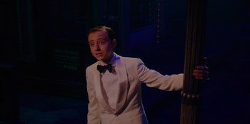 Movie still from “Better Nate Than Ever” (2022), directed by Tim Federle – A man in a white suit and a bow tie; Medium shot, Over the shoulder angle