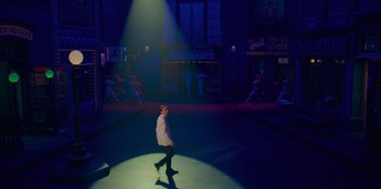 Movie still from “Better Nate Than Ever” (2022), directed by Tim Federle – A man is walking on a stage in the dark; Extreme Wide shot, Low angle