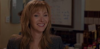 Movie still from “Better Nate Than Ever” (2022), directed by Tim Federle – A woman with long blonde hair smiling for the camera; Close Up shot, Over the shoulder angle