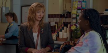 Movie still from “Better Nate Than Ever” (2022), directed by Tim Federle – A woman talking to a man sitting in a store; Medium shot, Over the shoulder angle