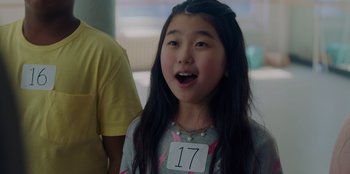 Movie still from “Better Nate Than Ever” (2022), directed by Tim Federle – A young girl with a number on her shirt; Close Up shot, Over the shoulder angle