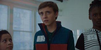 Movie still from “Better Nate Than Ever” (2022), directed by Tim Federle – A young boy wearing a blue and red jacket; Close Up shot, Over the shoulder angle