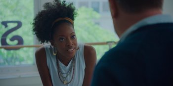 Movie still from “Better Nate Than Ever” (2022), directed by Tim Federle – A young woman sitting in front of a man in a suit; Close Up shot, Over the shoulder angle
