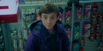 Movie still from “Better Nate Than Ever” (2022), directed by Tim Federle – A young boy in a purple jacket looking at the camera; Close Up shot, Low angle