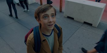 Movie still from “Better Nate Than Ever” (2022), directed by Tim Federle – A young boy with a backpack on the sidewalk; Close Up shot, Overhead angle