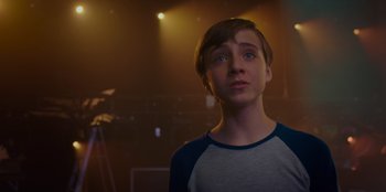 Movie still from “Better Nate Than Ever” (2022), directed by Tim Federle – A young man standing in front of a microphone; Close Up shot, Over the shoulder angle