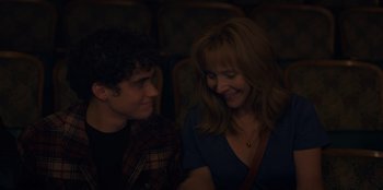 Movie still from “Better Nate Than Ever” (2022), directed by Tim Federle – A woman and a man are smiling at each other; Close Up shot, Over the shoulder angle