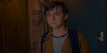 Movie still from “Better Nate Than Ever” (2022), directed by Tim Federle – A young man with a backpack looking to his left; Close Up shot, Over the shoulder angle