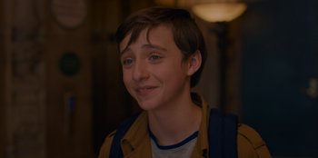 Movie still from “Better Nate Than Ever” (2022), directed by Tim Federle – A young boy with a blue shirt and brown jacket; Close Up shot, Over the shoulder angle