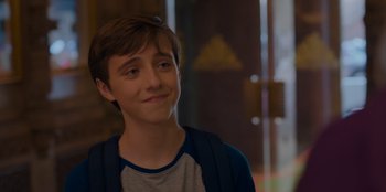 Movie still from “Better Nate Than Ever” (2022), directed by Tim Federle – A young man is smiling for the camera; Close Up shot, Over the shoulder angle