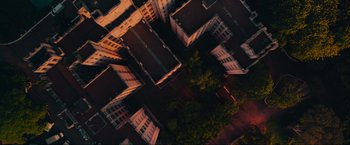 Movie still from “Beyond the Universe” (2022), directed by Diego Freitas – An aerial view of some buildings and a tree; Extreme Wide shot, Overhead angle
