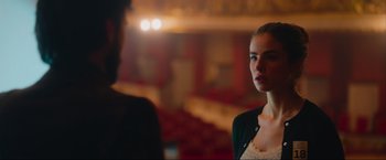 A woman standing in front of a man in a theater