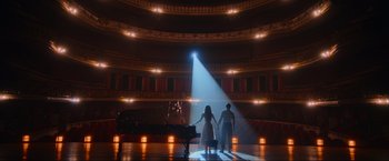 Two people are holding hands in a theater