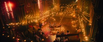 A group of people sitting around a piano in a room