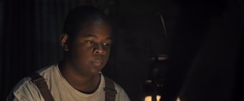 Movie still from “Big George Foreman” (2023), directed by George Tillman Jr. – A young man is looking into the light; Close Up shot, Low angle