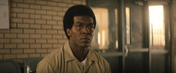 Movie still from “Big George Foreman” (2023), directed by George Tillman Jr. – A man in a tan shirt and a white shirt; Close Up shot, Low angle