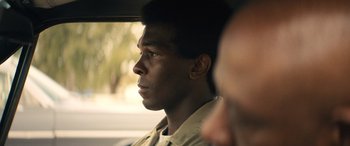 Movie still from “Big George Foreman” (2023), directed by George Tillman Jr. – A man sitting in a car looking out the window; Close Up shot, Over the shoulder angle