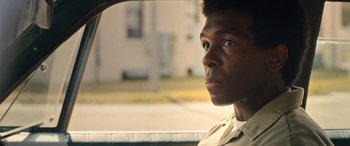 Movie still from “Big George Foreman” (2023), directed by George Tillman Jr. – A man sitting in the back of a car looking out the window; Close Up shot, Over the shoulder angle