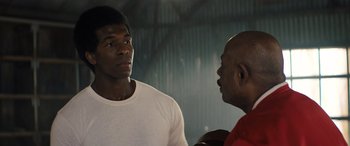 Movie still from “Big George Foreman” (2023), directed by George Tillman Jr. – A man and a man standing next to each other; Close Up shot, Over the shoulder angle