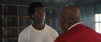 Movie still from “Big George Foreman” (2023), directed by George Tillman Jr. – A man standing next to another man in front of a mirror; Close Up shot, Over the shoulder angle