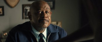 Movie still from “Big George Foreman” (2023), directed by George Tillman Jr. – An older man wearing a blue jacket and a blue tie; Close Up shot, Over the shoulder angle