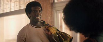 Movie still from “Big George Foreman” (2023), directed by George Tillman Jr. – A man holding onto a yellow and green tie; Close Up shot, Over the shoulder angle