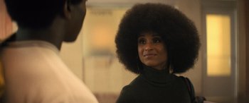 Movie still from “Big George Foreman” (2023), directed by George Tillman Jr. – A woman with a large afro looking into a mirror; Close Up shot, Over the shoulder angle