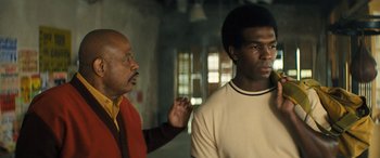 Movie still from “Big George Foreman” (2023), directed by George Tillman Jr. – Two men standing next to each other in a room; Medium shot, Over the shoulder angle