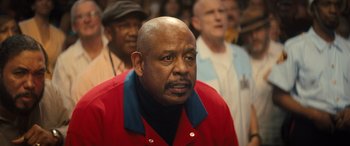 Movie still from “Big George Foreman” (2023), directed by George Tillman Jr. – An older man in a red jacket is looking straight ahead; Close Up shot, Low angle
