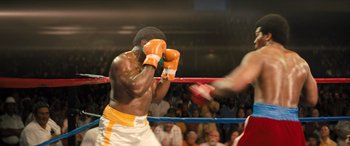 Movie still from “Big George Foreman” (2023), directed by George Tillman Jr. – Two boxers in a boxing ring during a match; Medium shot, High angle