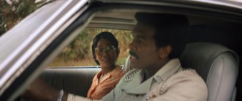 Movie still from “Big George Foreman” (2023), directed by George Tillman Jr. – A man and a woman sitting in the back of a car; Close Up shot, Over the shoulder angle