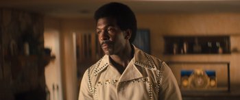 Movie still from “Big George Foreman” (2023), directed by George Tillman Jr. – A man in a tan jacket with silver studs on it's sleeves; Close Up shot, Low angle
