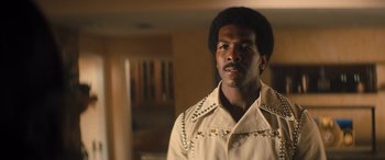 Movie still from “Big George Foreman” (2023), directed by George Tillman Jr. – A man in a white jacket with silver studs on it's sleeves; Close Up shot, Low angle