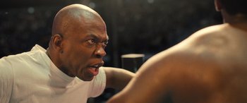 Movie still from “Big George Foreman” (2023), directed by George Tillman Jr. – A man with a surprised look on his face; Close Up shot, Over the shoulder angle