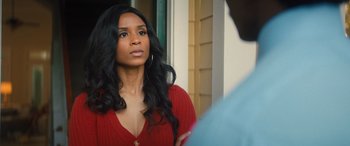 Movie still from “Big George Foreman” (2023), directed by George Tillman Jr. – A woman in a red shirt is looking at a man; Close Up shot, Over the shoulder angle