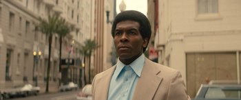 Movie still from “Big George Foreman” (2023), directed by George Tillman Jr. – A man in a suit standing on the side of the street; Close Up shot, Low angle