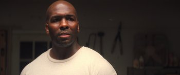 Movie still from “Big George Foreman” (2023), directed by George Tillman Jr. – A man with a bald head is standing in front of a wall; Close Up shot, Low angle