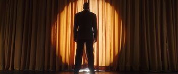 Movie still from “Big George Foreman” (2023), directed by George Tillman Jr. – A man standing in front of an orange curtain; Wide shot, Low angle