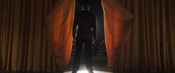 Movie still from “Big George Foreman” (2023), directed by George Tillman Jr. – A man standing in front of a curtain; Wide shot, Low angle