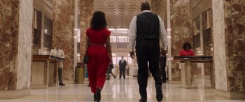 Movie still from “Big George Foreman” (2023), directed by George Tillman Jr. – A man and a woman are walking in a lobby; Wide shot, Low angle