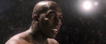 Movie still from “Big George Foreman” (2023), directed by George Tillman Jr. – A man's face in a boxing ring; Close Up shot, Low angle