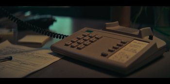 Movie still from “Big Mäck - Gangsters and Gold” (2023), directed by Andreas Spinrath – An old phone sitting on top of a desk; Extreme Close Up shot, High angle