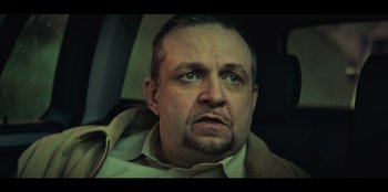A person in a car looking at the camera