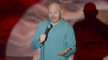 Movie still from “Bill Burr: Live at Red Rocks” (2022), directed by Mike Binder – A bald man holding a microphone in his hand; Medium shot, High angle