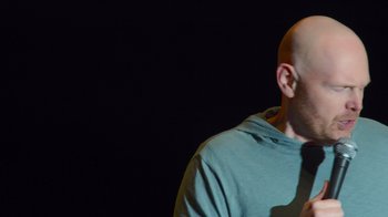 Movie still from “Bill Burr: Live at Red Rocks” (2022), directed by Mike Binder – A man with bald head wearing a blue shirt; Close Up shot, Low angle