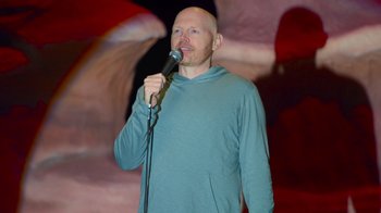 Movie still from “Bill Burr: Live at Red Rocks” (2022), directed by Mike Binder – A bald man is holding a microphone in his hand; Medium shot, High angle