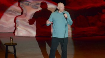 Movie still from “Bill Burr: Live at Red Rocks” (2022), directed by Mike Binder – A man standing on a stage with a microphone in his hand; Wide shot, High angle