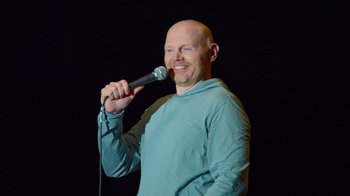 Movie still from “Bill Burr: Live at Red Rocks” (2022), directed by Mike Binder – A bald man holding a microphone up to his mouth; Close Up shot, Low angle